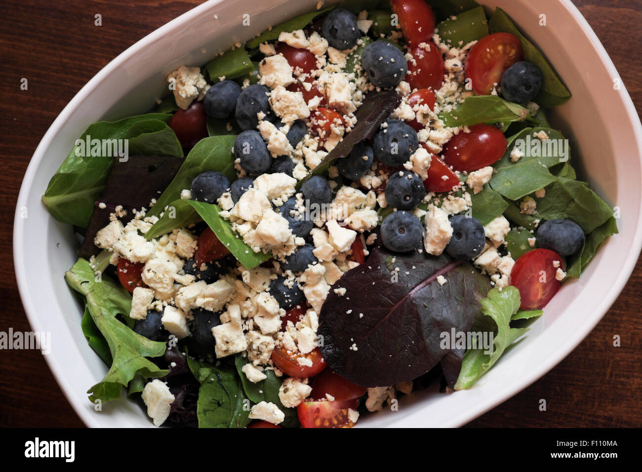 Foglia verde con insalata di pomodori, mirtilli e il formaggio feta. Foto Stock