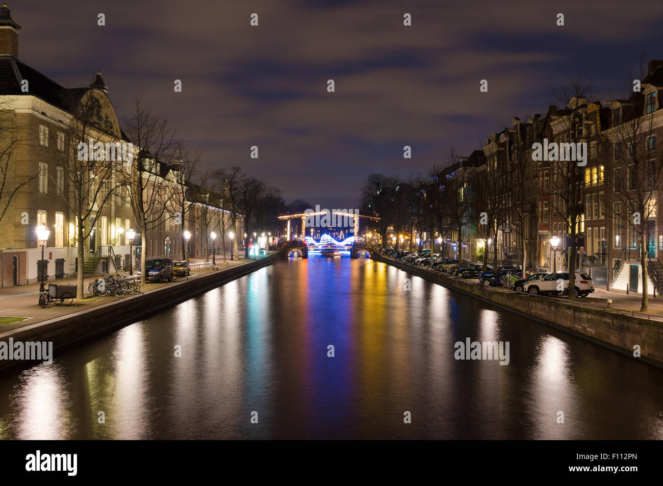 Illuminata sul canale di Amsterdam e ponte levatoio di notte Foto Stock