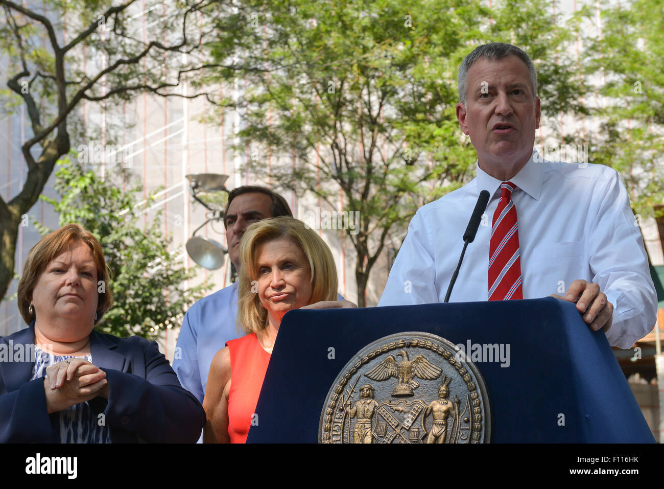 New York, Stati Uniti. 24 Ago, 2015. Membro Assemblywoman Catherine Nolan (sinistra), E DEGLI STATI UNITI Congressista Carolyn Maloney (centro) di ascoltare come sindaco de Blasio discuses la sostituzione sul tetto che si verificano in corrispondenza della Queensbridge Case. Sindaco di Bill de Blasio uniti con selezionare federali, statali e locali di annunciare la sostituzione dei tetti a NYCHA Queensbridge case, le nazioni più vasto complesso di abitazioni e di spiegare gli obiettivi della "NextGeneration NYCHA' alloggiamento pubblico revamping. Credito: Albin Lohr-Jones/Pacific Press/Alamy Live News Foto Stock