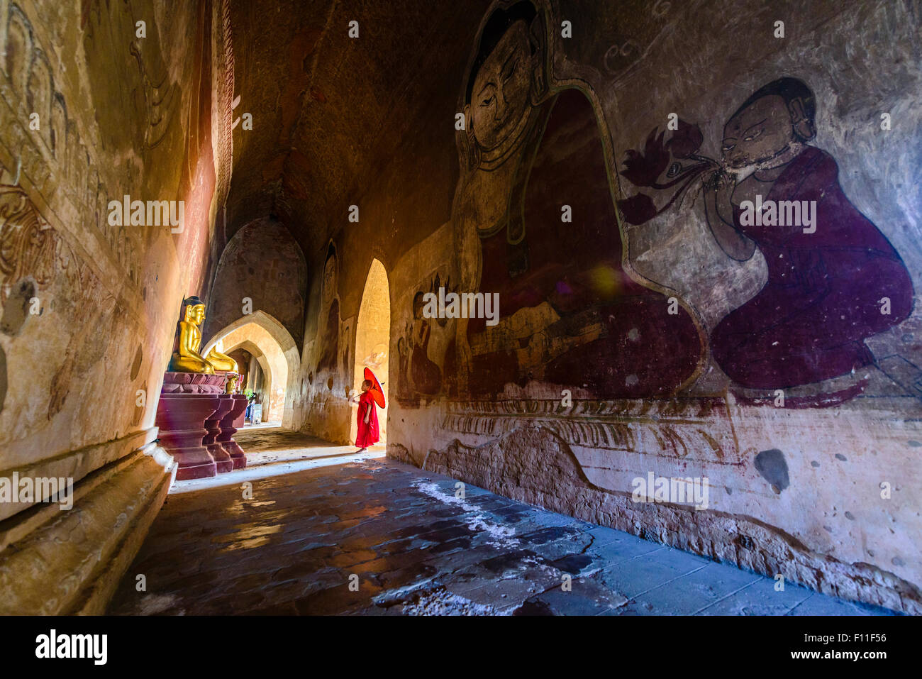 Asian monaco-in-formazione a piedi nella fatiscente tempio di pietra Foto Stock