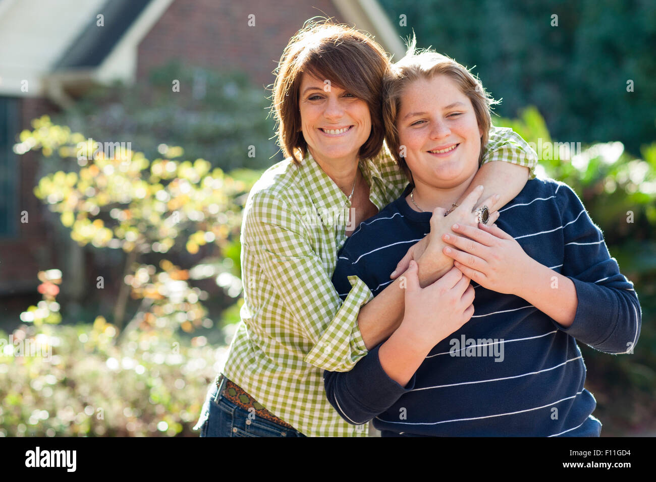 Caucasian madre e figlio abbraccia all'aperto Foto Stock