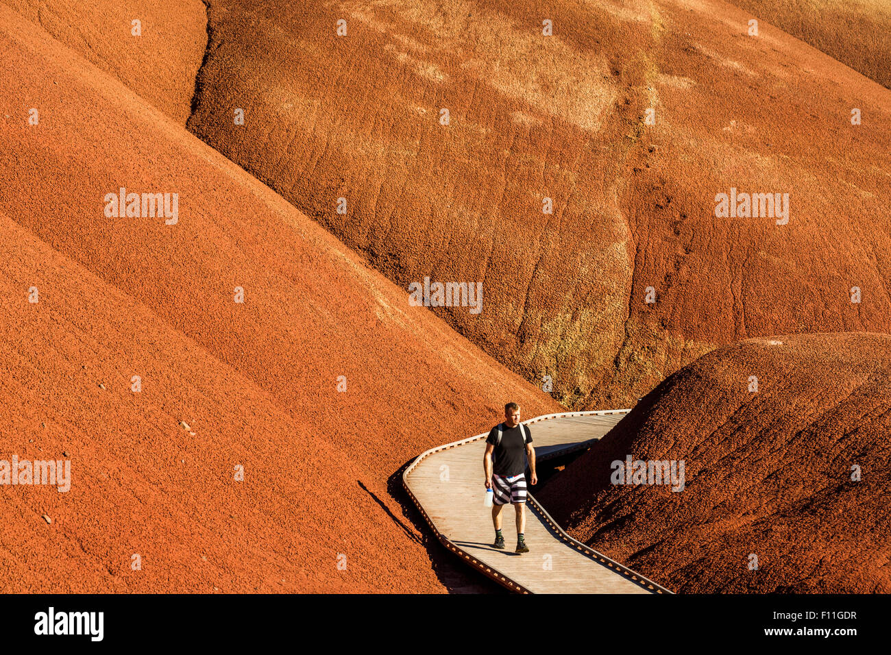 Escursionista caucasica sulla passerella di legno nelle colline del deserto Foto Stock