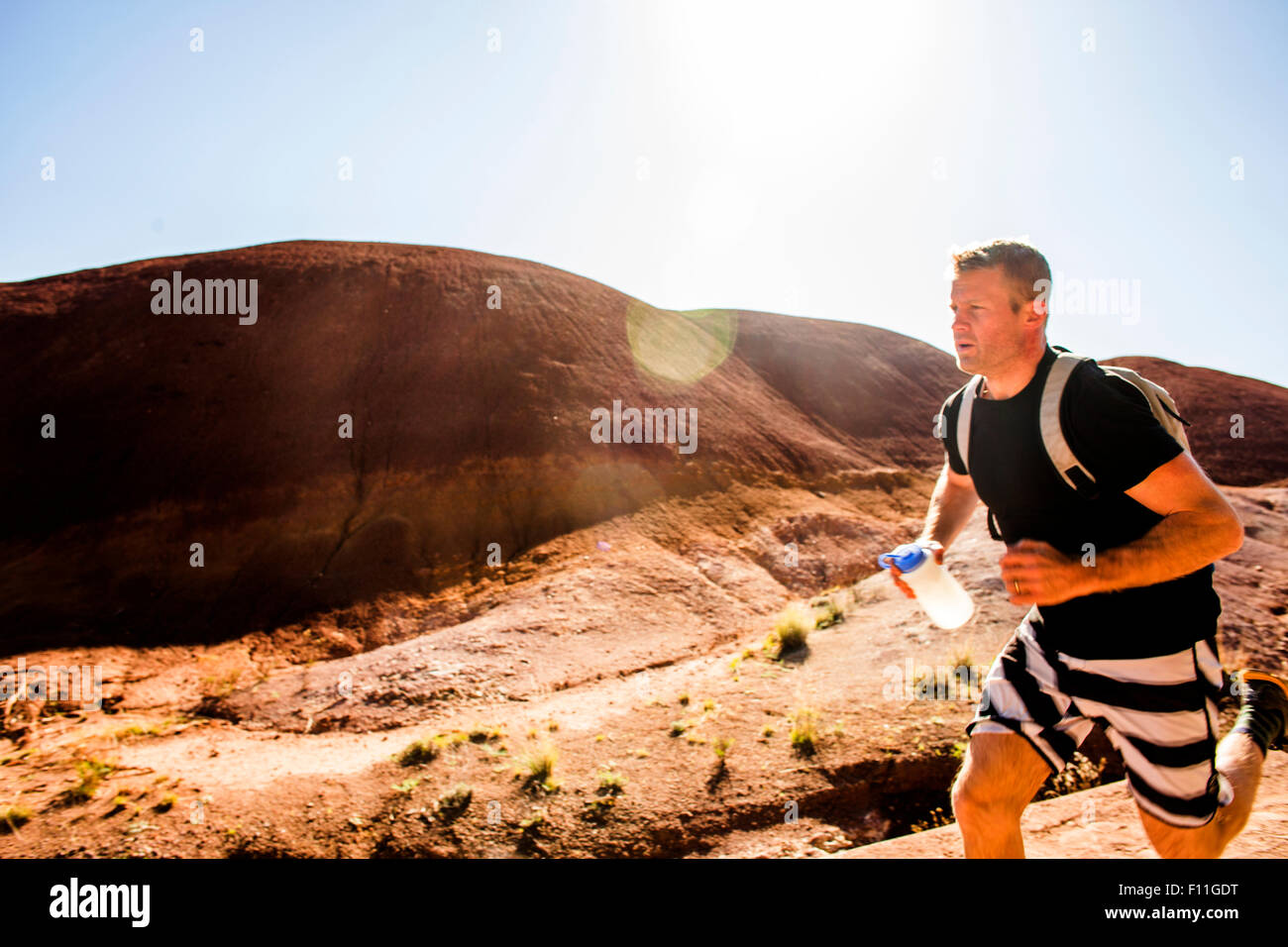 Uomo caucasico in esecuzione in colline del deserto Foto Stock