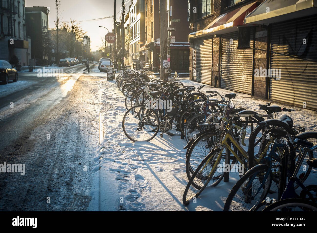 Le biciclette parcheggiate nella neve sul marciapiede della città di New York, New York, Stati Uniti Foto Stock