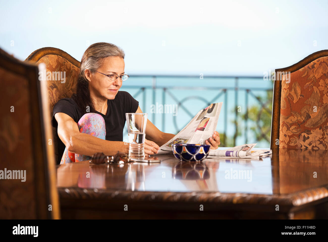 Donna ispanica quotidiano di lettura a tavola Foto Stock