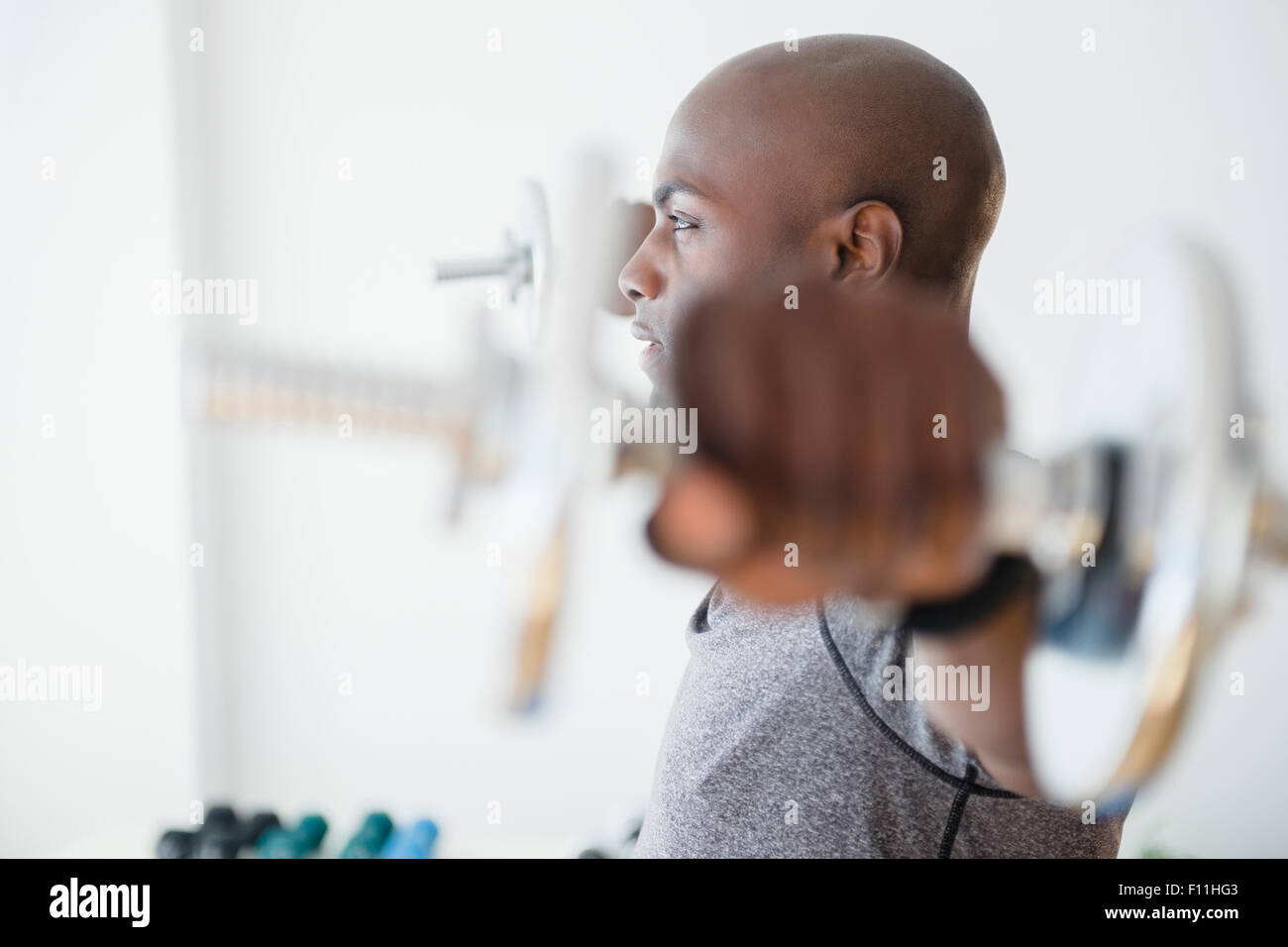 Uomo nero il sollevamento pesi nella palestra Foto Stock