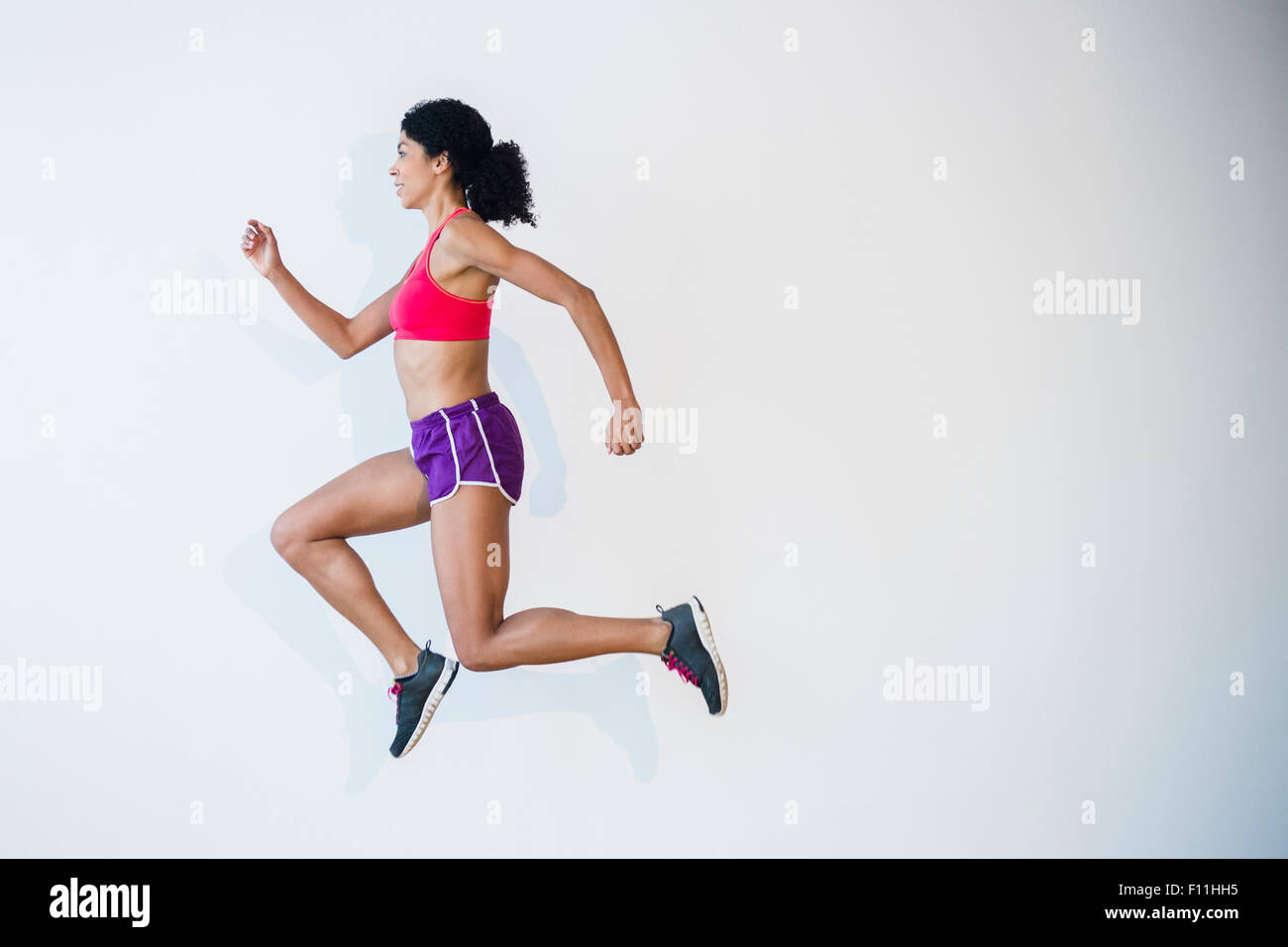 Vista laterale di razza mista donna in esecuzione Foto Stock
