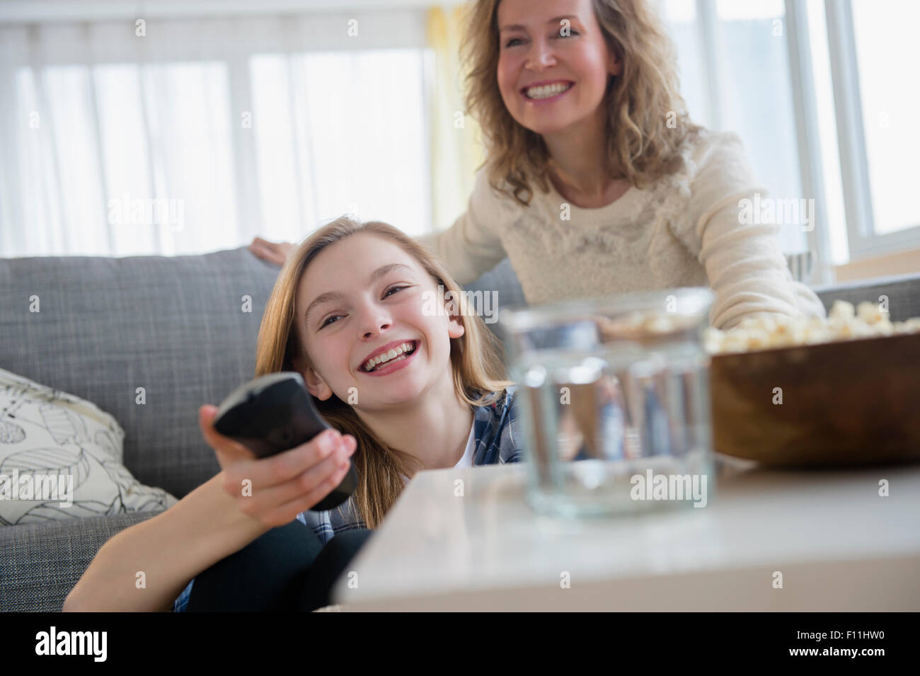 Caucasian madre e figlia di guardare la televisione sul divano Foto Stock