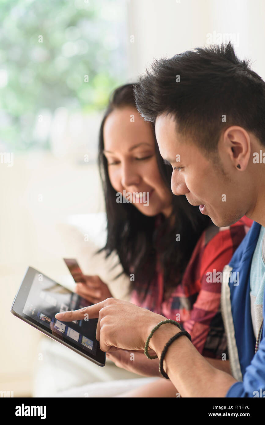 Chiusura del giovane lo shopping online su tavoletta digitale Foto Stock