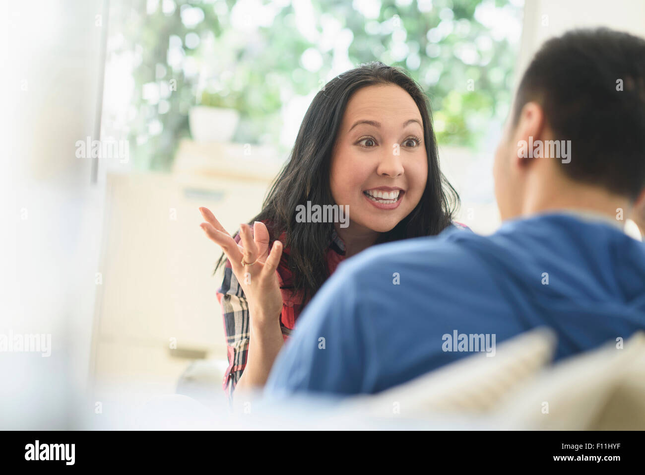 Paio di parlare sul divano nel soggiorno Foto Stock