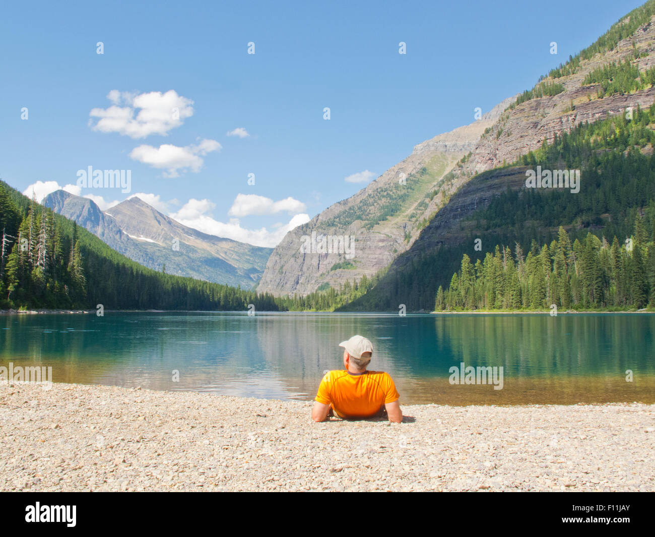 Escursionista posa vicino lago di montagna, il Parco Nazionale di Glacier, Montana, Stati Uniti Foto Stock