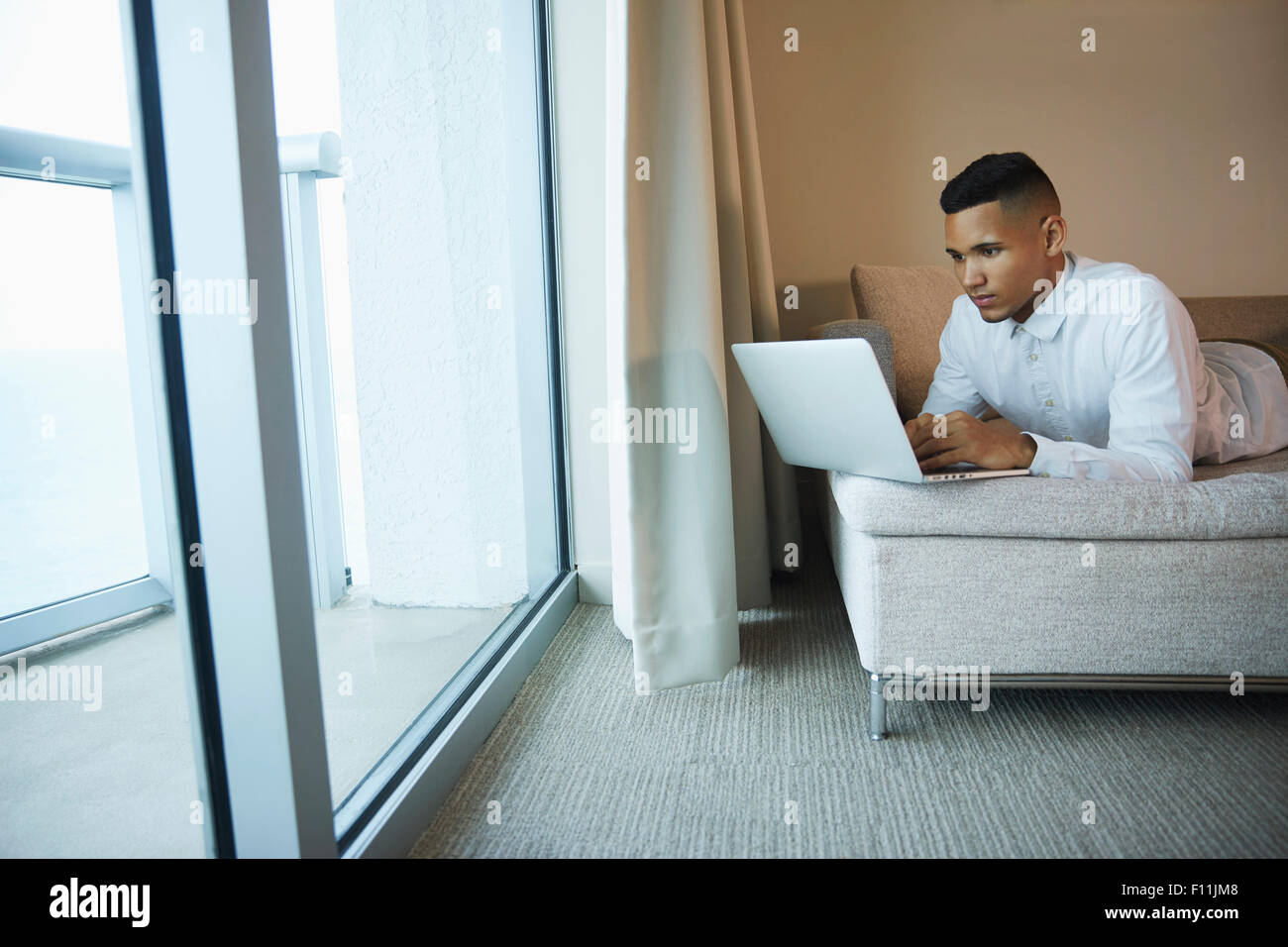 Imprenditore nero utilizzando computer portatile in camera di albergo Foto Stock