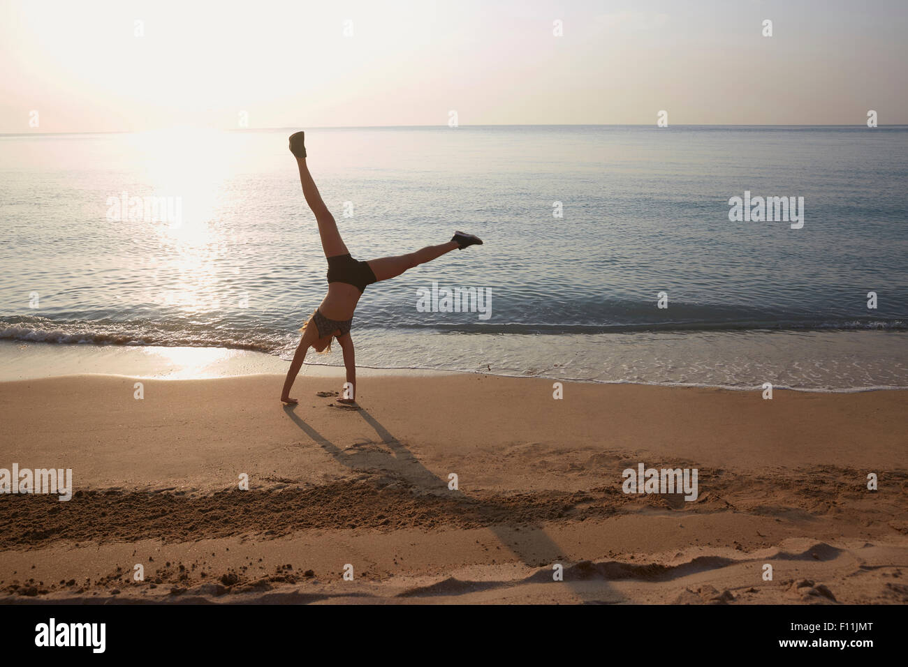 Atleta facendo appoggiate sulla spiaggia Foto Stock