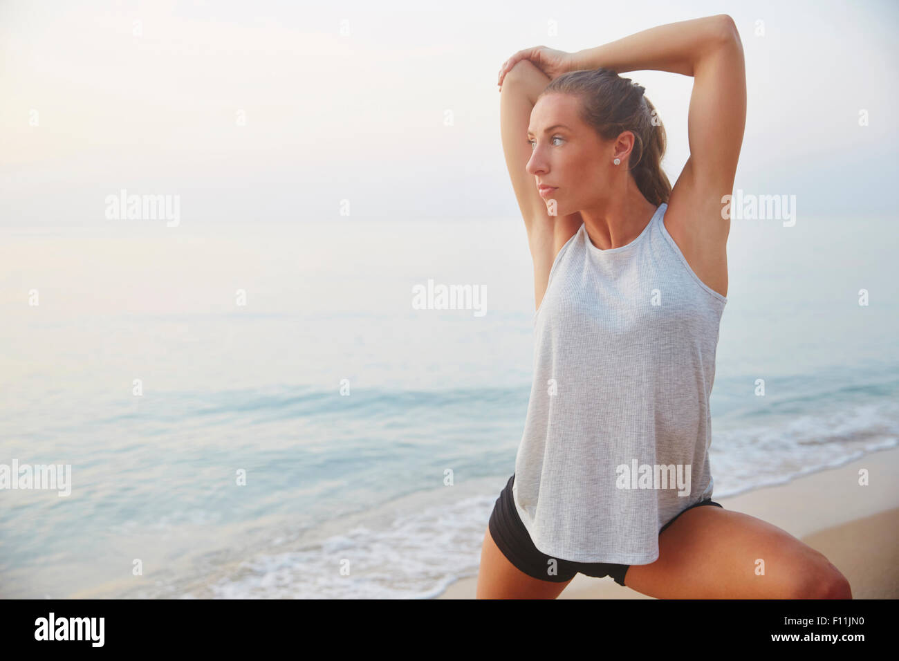 Atleta stiramento sulla spiaggia Foto Stock