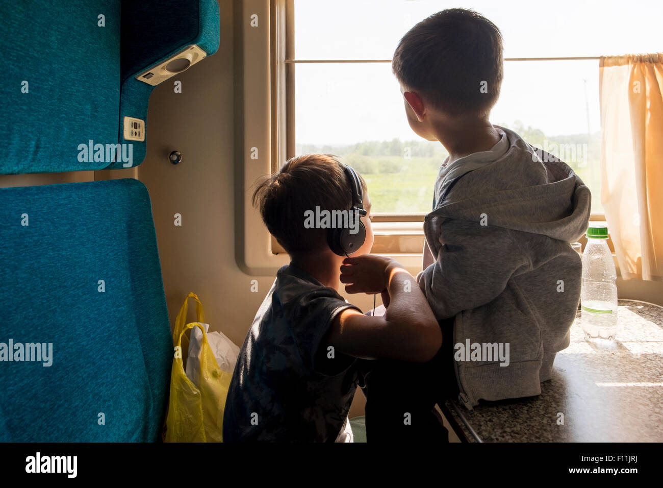Mari fratelli a guardare fuori dalla finestra del treno Foto Stock