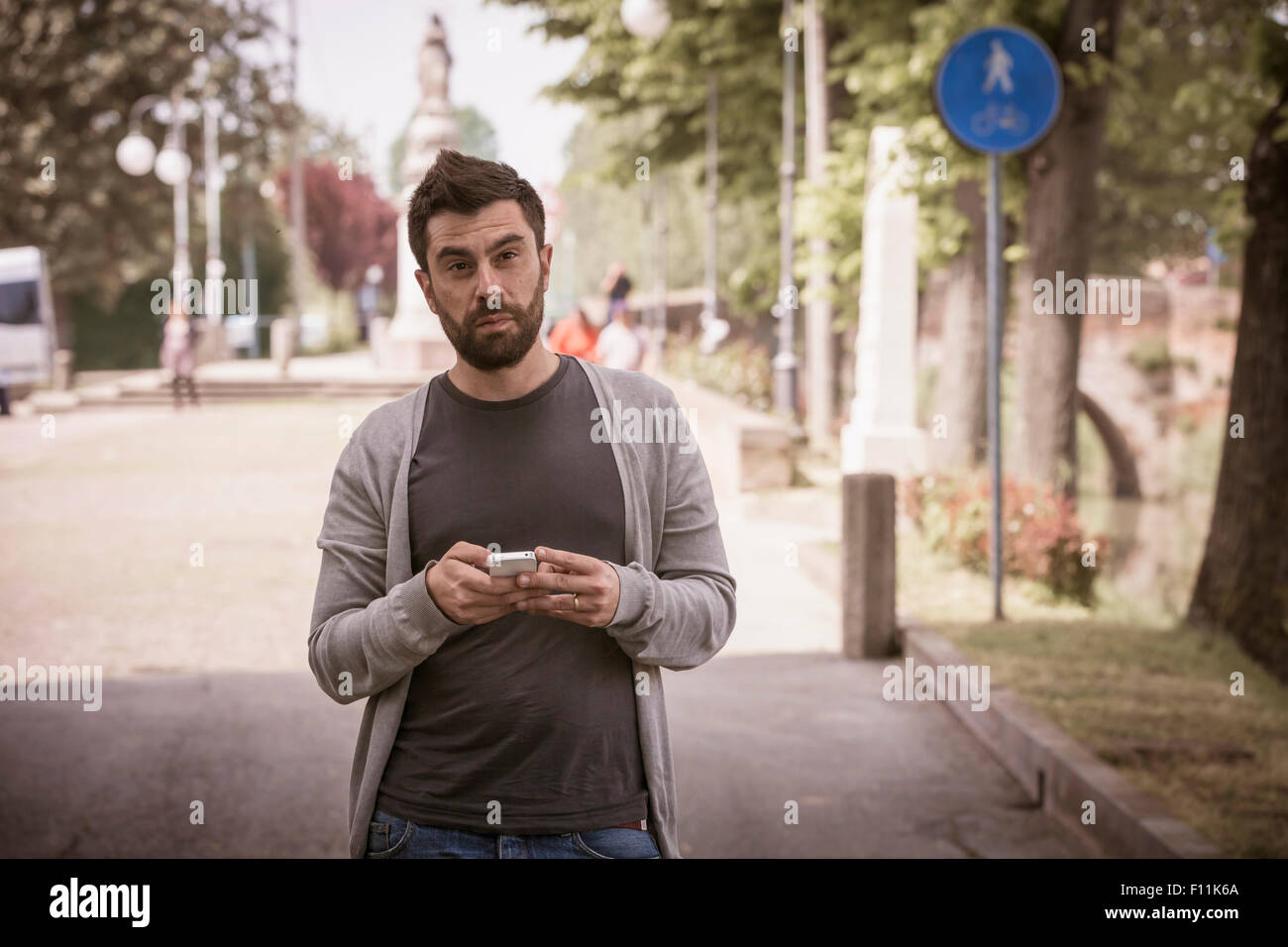 Uomo caucasico tramite telefono cellulare su strada urbana Foto Stock