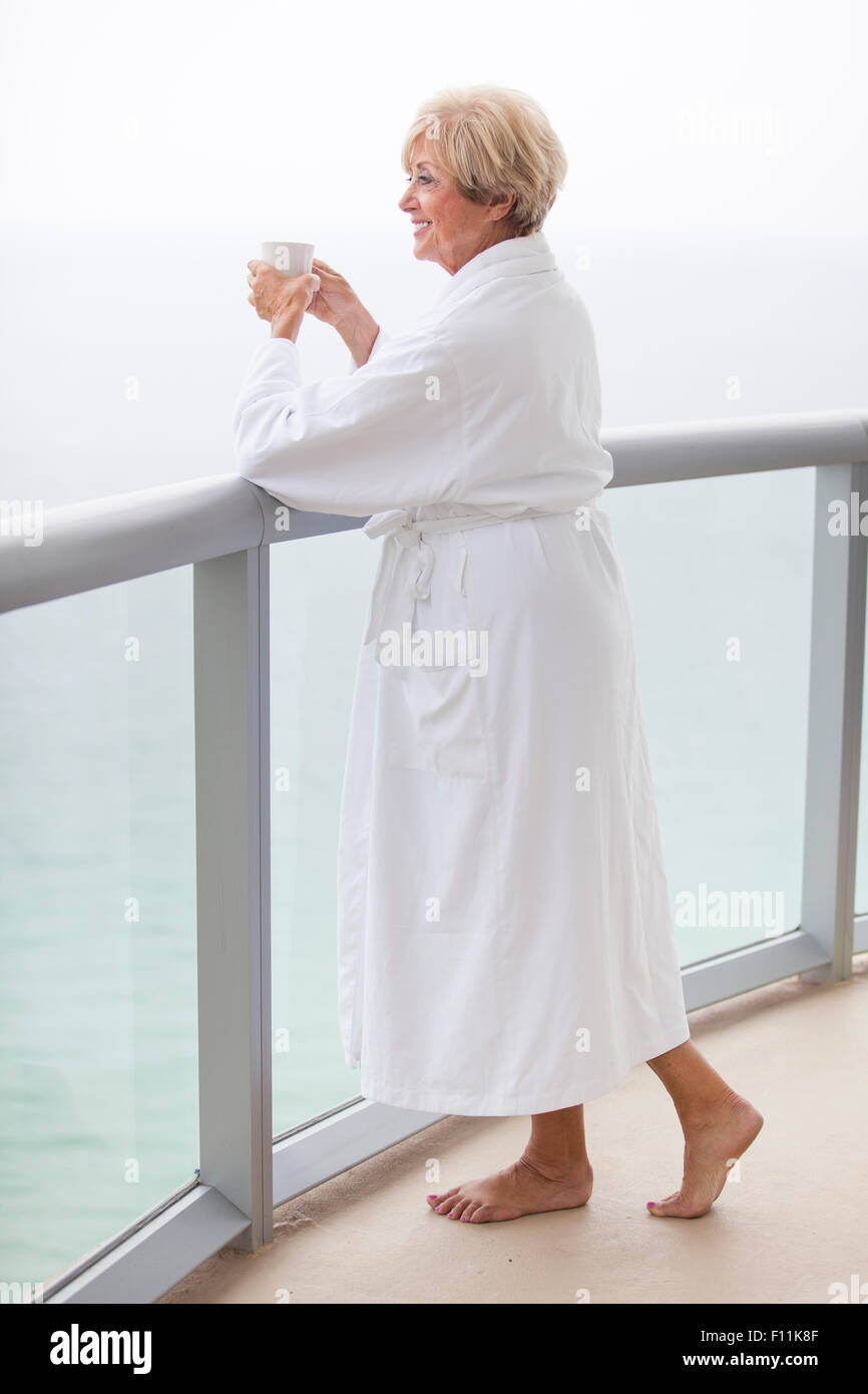 I vecchi donna caucasici di bere il caffè sul balcone Foto Stock