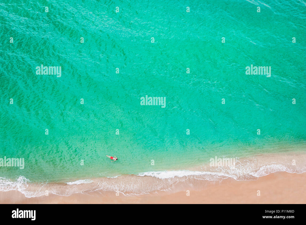 Vista aerea del uomo caucasico nuoto in mare sulla spiaggia Foto Stock
