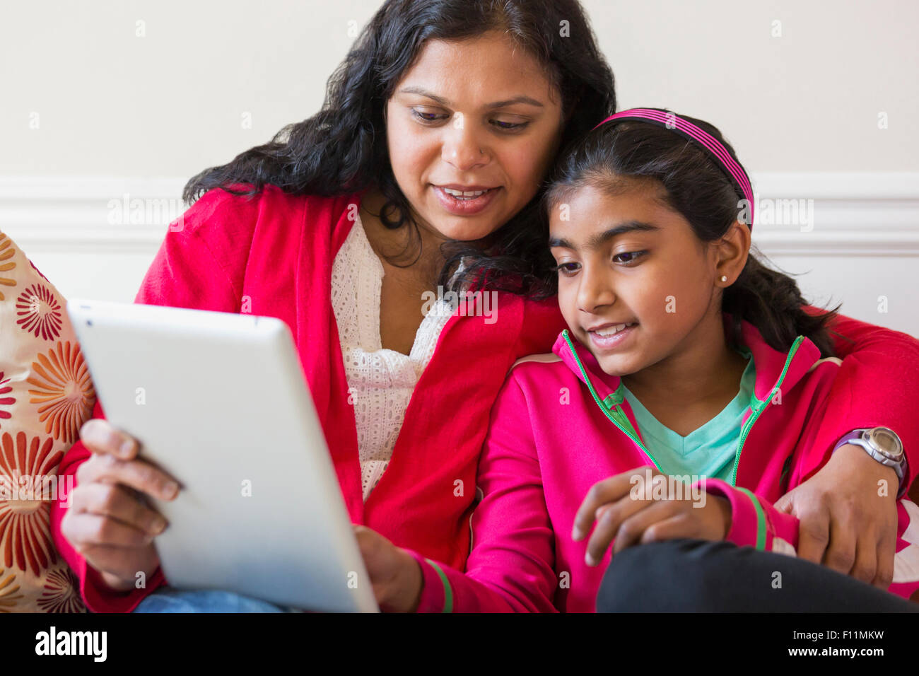 Indian madre e figlia con tavoletta digitale Foto Stock
