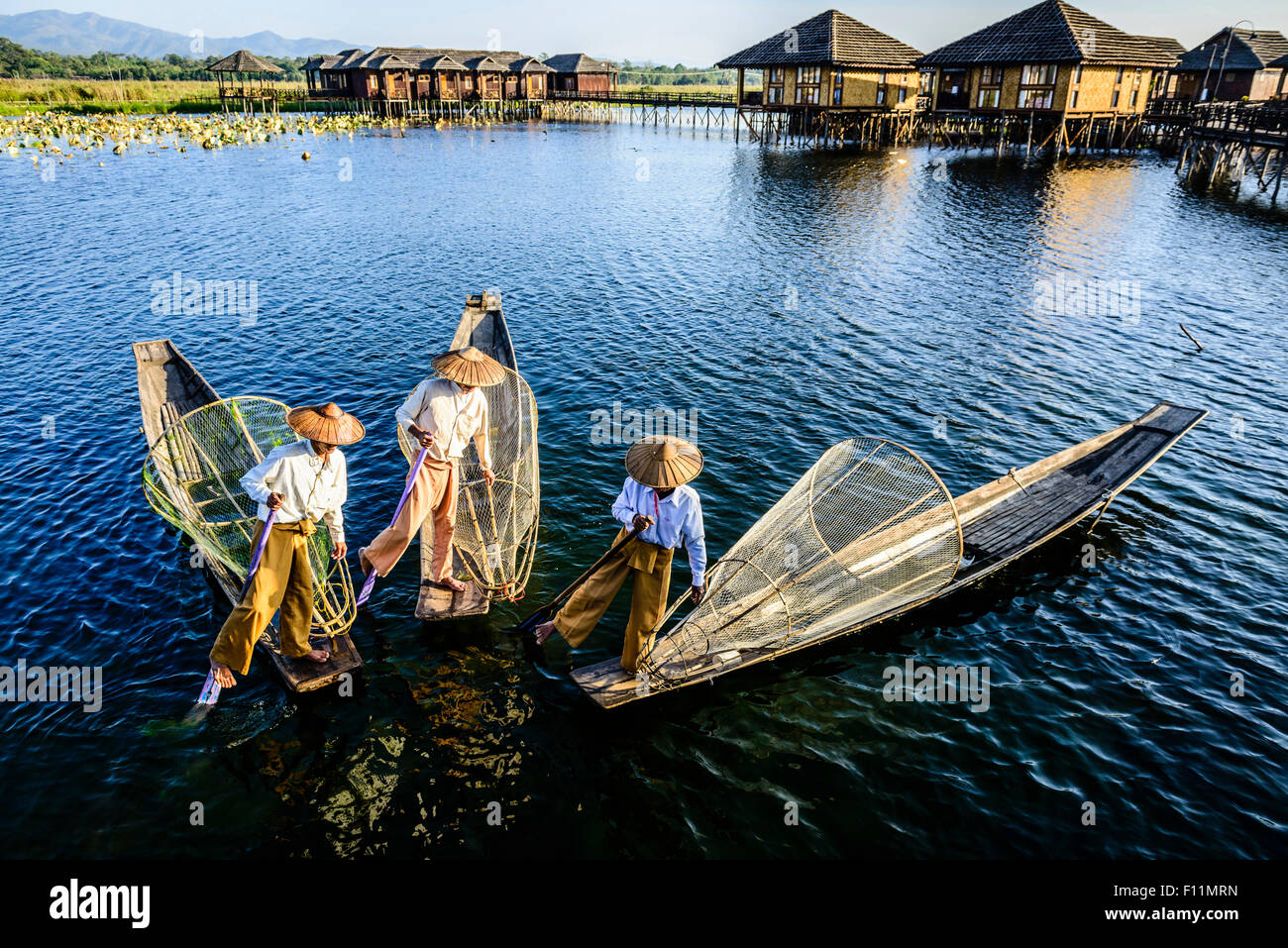 Asian pescatori pesca in canoa sul fiume Foto Stock