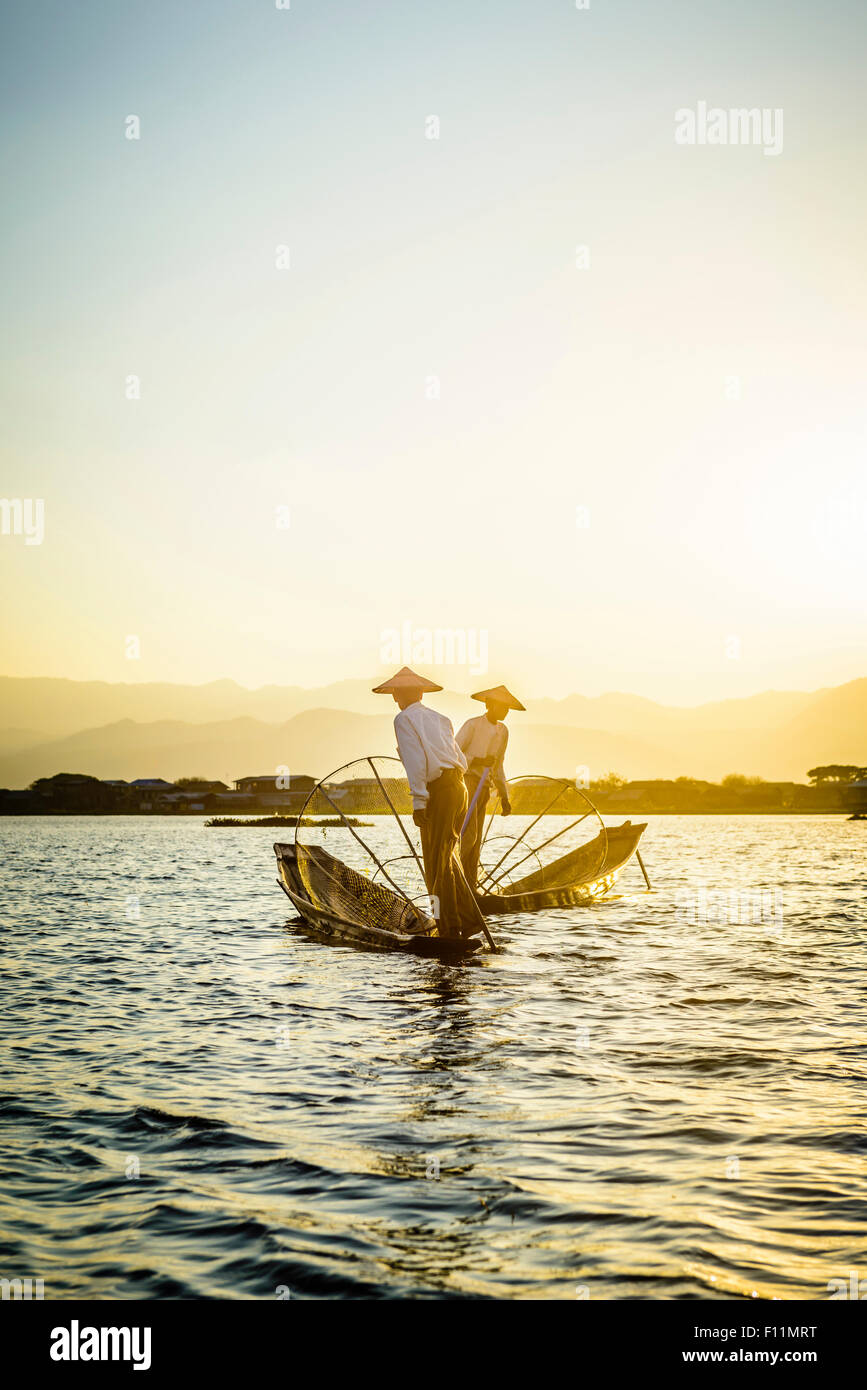 Asian pescatori pesca in canoa sul fiume Foto Stock