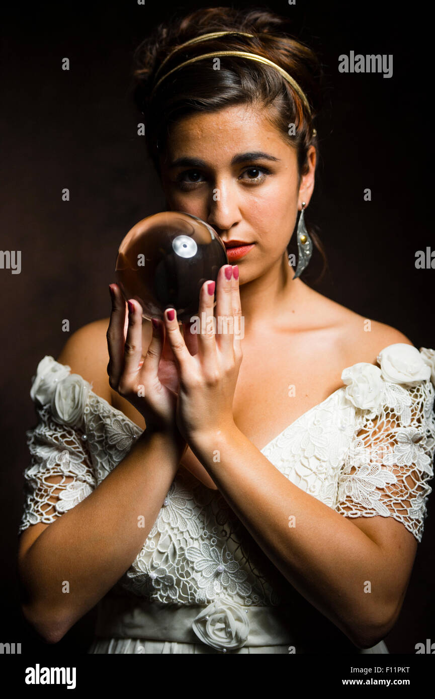 Indovino - un giovane di oliva-scuoiati donna ragazza con una sfera di  cristallo - esaminando e la previsione del futuro Foto stock - Alamy