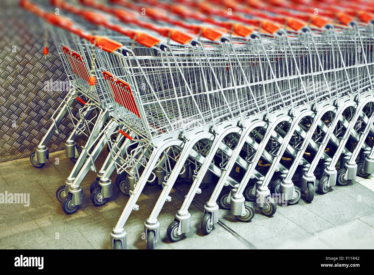 Riga di una pila di carrelli per supermercati Foto Stock