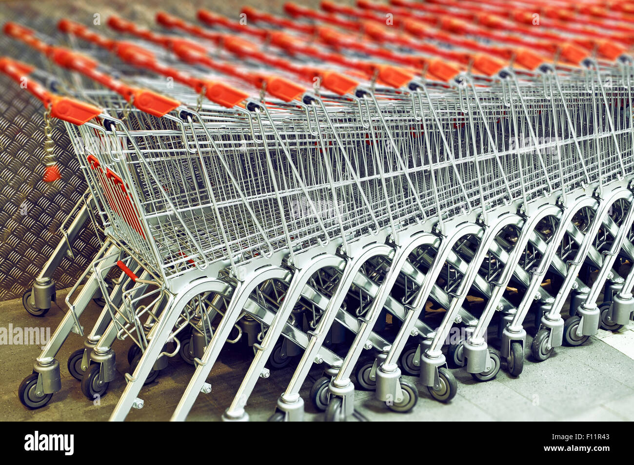 Riga di una pila di carrelli per supermercati Foto Stock