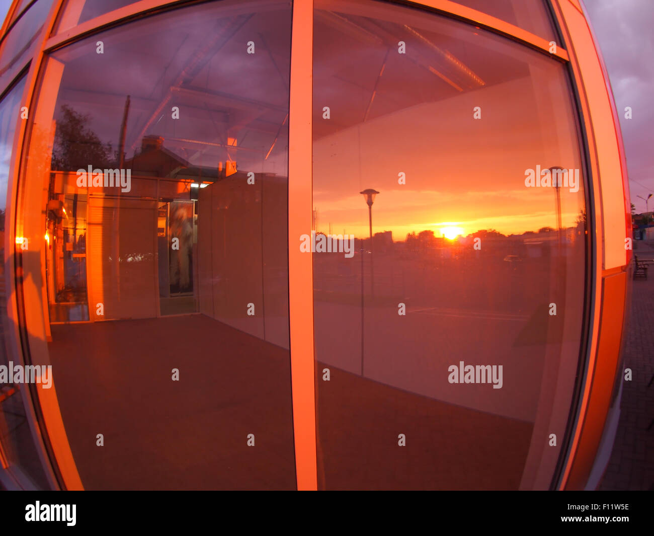Paesaggio al tramonto, che è riflessa nella vetrina di un negozio vuoto locali con ampio angolo lente fisheye e vista di distorsione Foto Stock