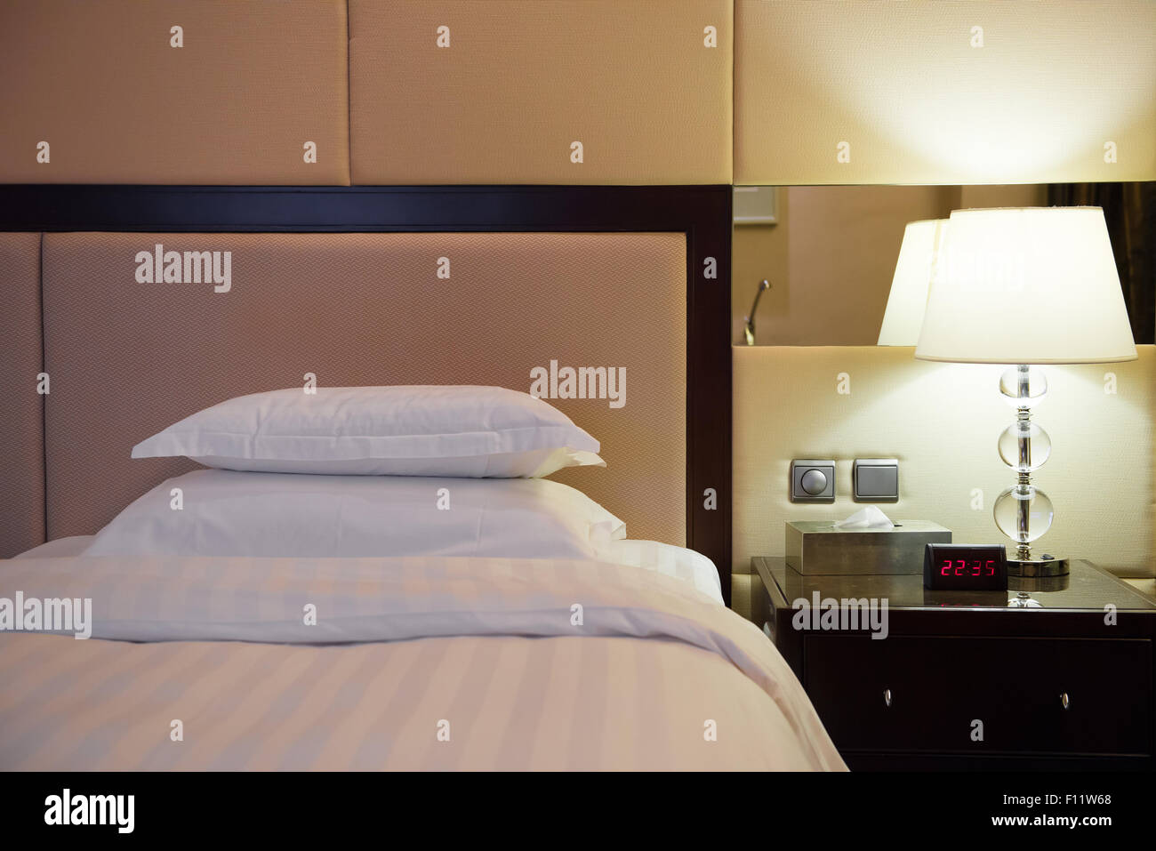 Il letto e la lampada in una camera di hotel Foto Stock