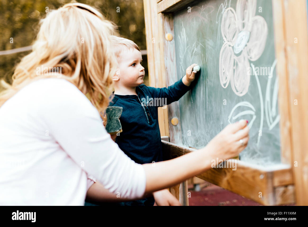 Bella madre e figlio disegno sulla lavagna con Chalk Foto Stock