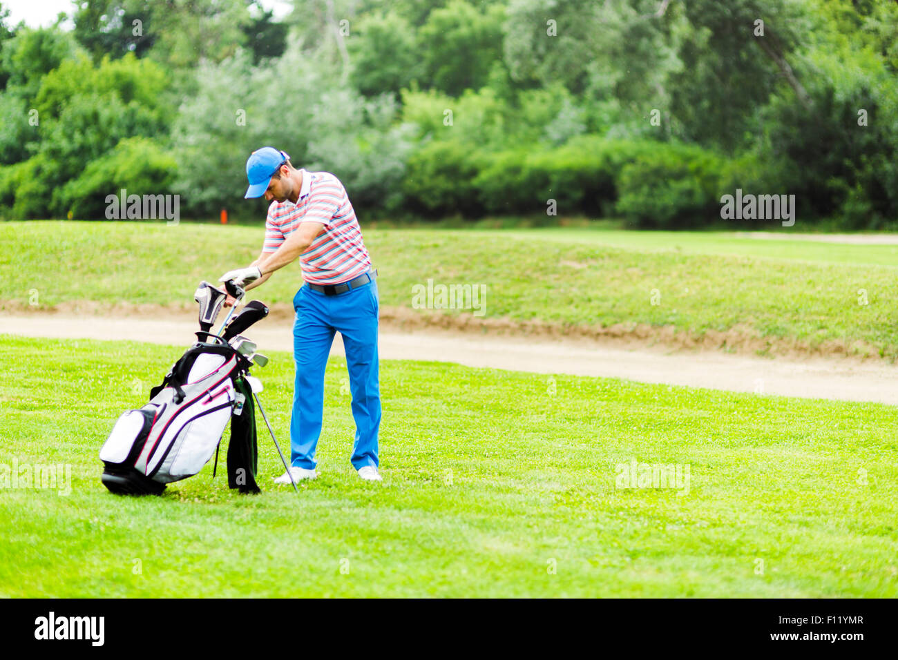 Il Golfer appropriata selezione club per il prossimo colpo Foto Stock