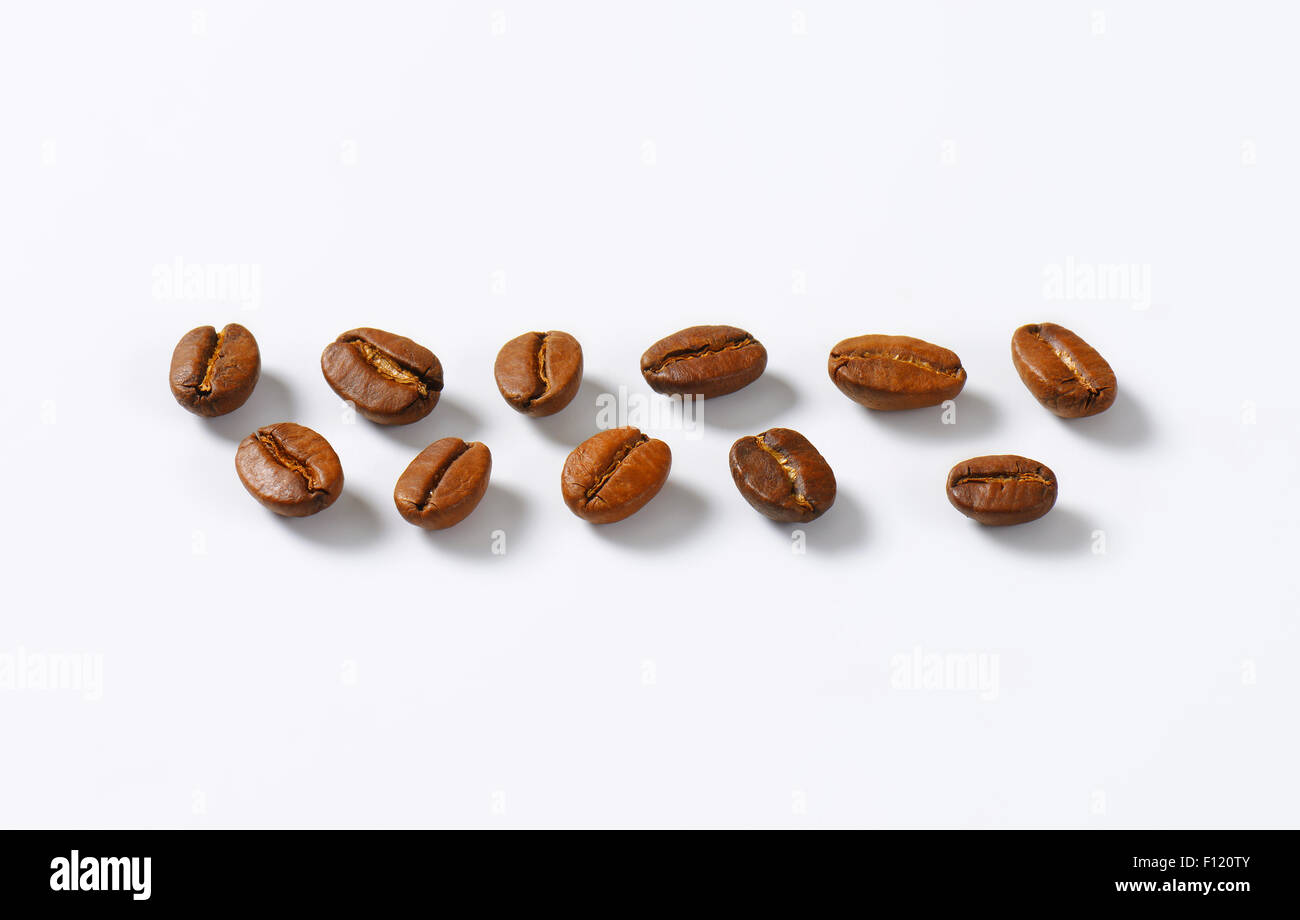 Chicchi di caffè tostati disposti in linee Foto Stock