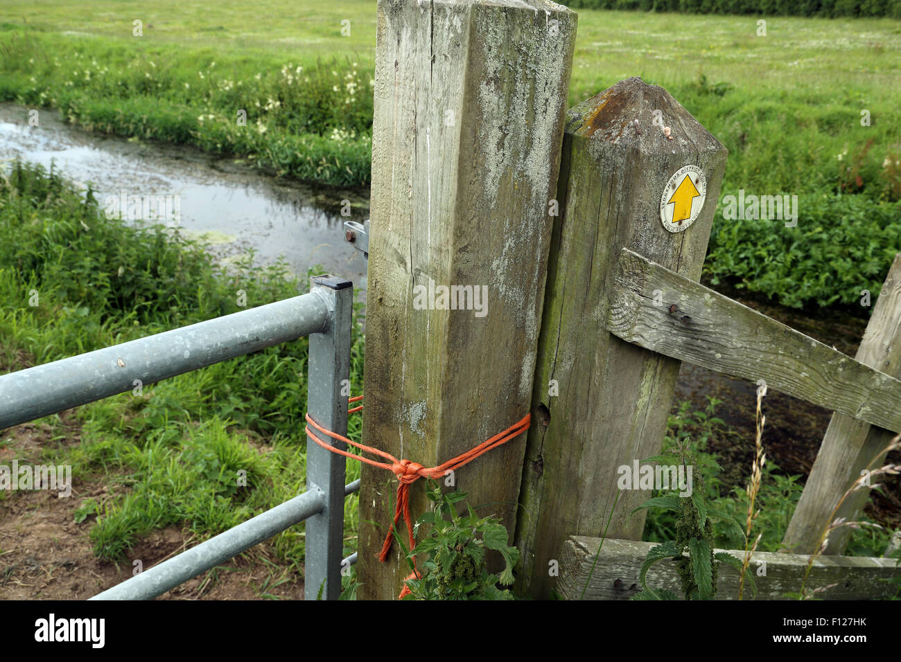 Chiaramente un sentiero bloccato da qualcuno, presumibilmente l'agricoltore, la legatura forte corda arancione intorno al gate e gatepost. Foto Stock