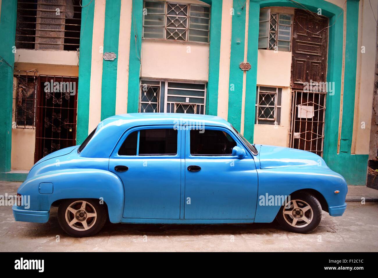 Turchese brillante lucido, auto con vetri colorati, parcheggiata in una strada residenziale a l'Avana, Cuba. Foto Stock