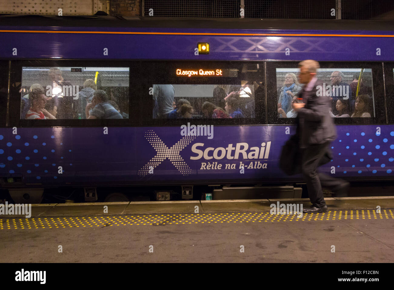 La Gaelic branding ScotRail sul treno che viaggia tra Edinburgh Waverley e Glasgow Queen Street Station Foto Stock
