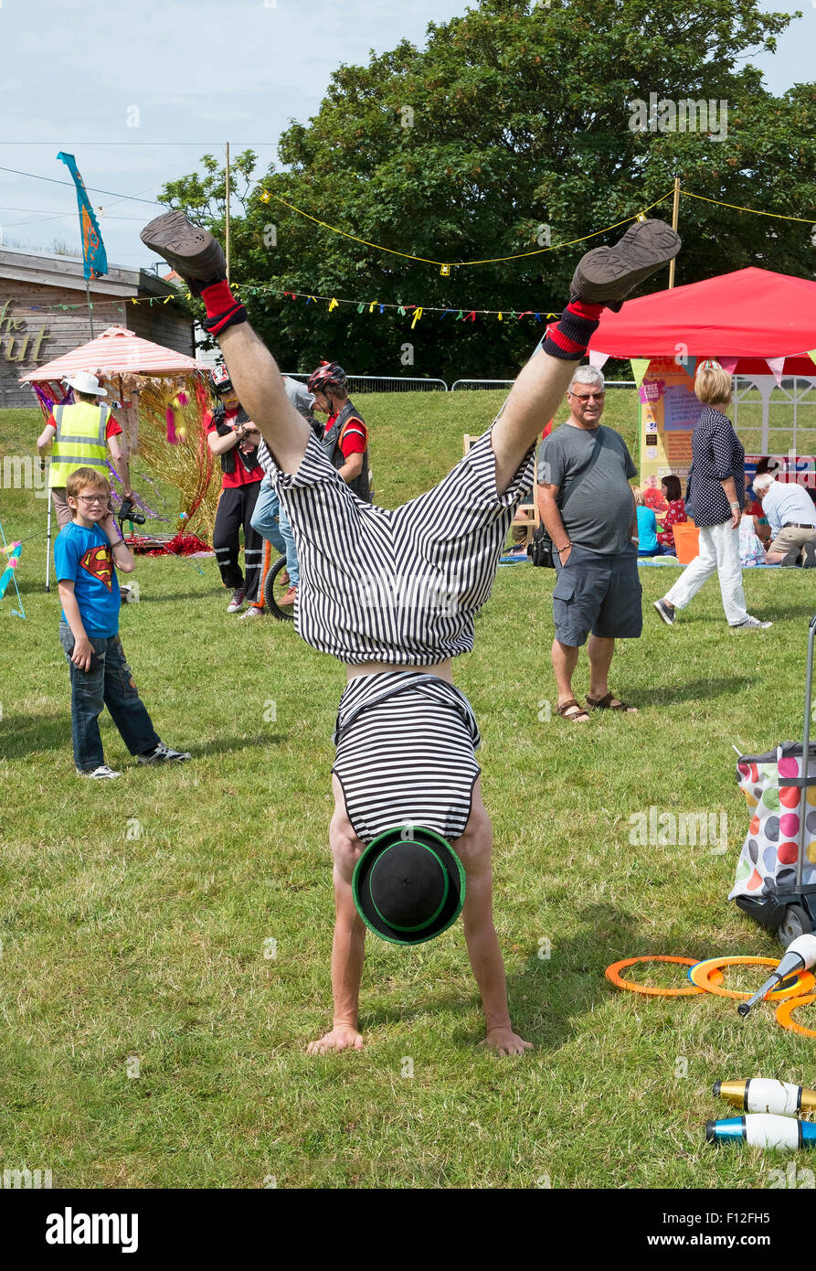 Un animatore per bambini facendo un handstand Foto Stock