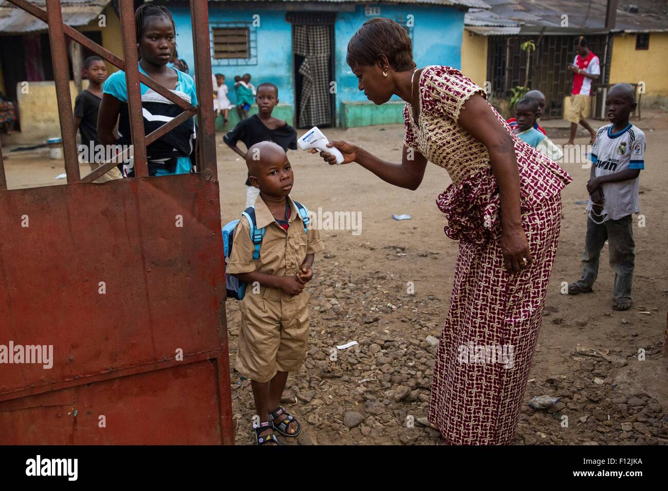 Un giovane ragazzo scuola ha la sua temperatura controllata per il virus Ebola dopo gli studenti sono tornati alle scuole che erano state chiuse per un periodo di tre mesi durante il focolaio 19 Gennaio 2015 a Conakry, in Guinea. Foto Stock