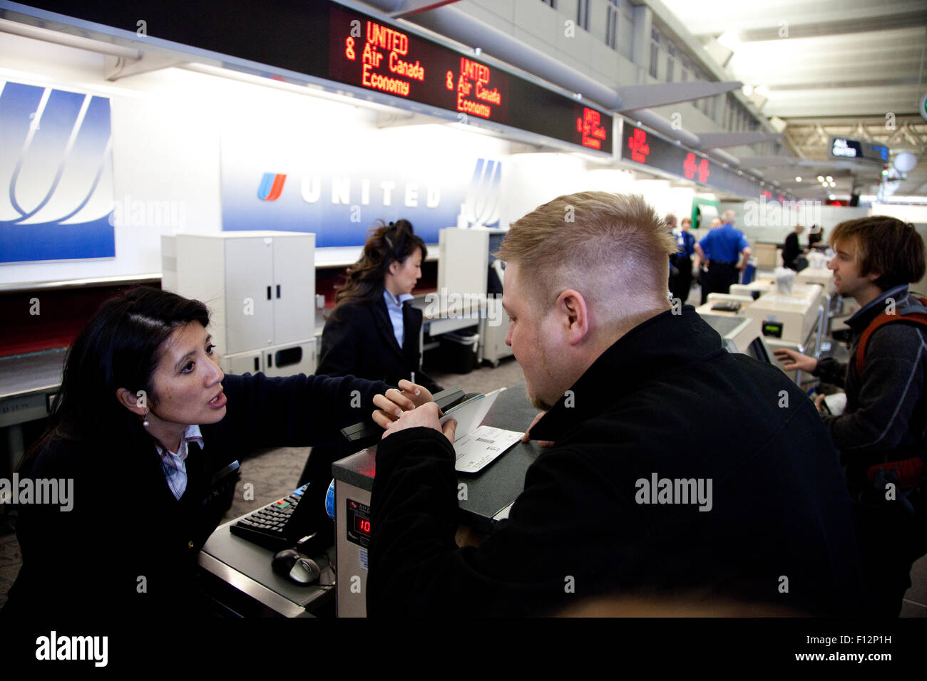 Donna attendant aiutare l uomo all'aeroporto al banco check-in. Minneapolis Minnesota MN USA Foto Stock