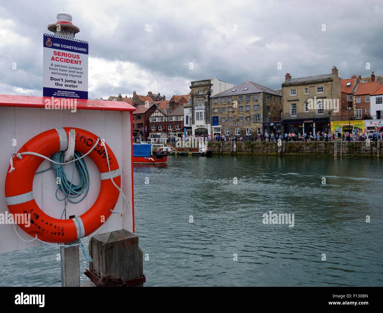 Segnale di avviso di un grave incidente al di sopra di un salvagente in un porto di pesca Foto Stock