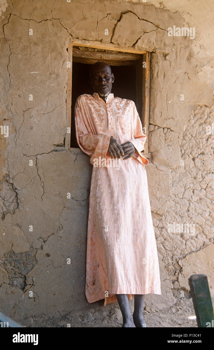 Ritratto di villaggio negoziante al di fuori di edificio rurale, Ciad, 2002-2003. Foto Stock