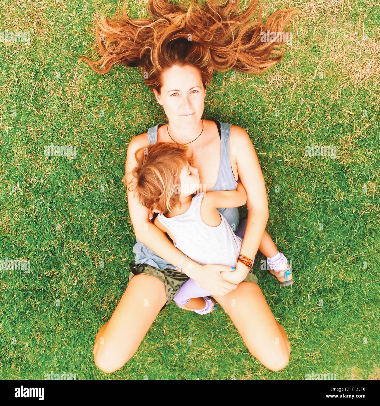 Vista aerea di una donna sdraiata su erba con sua figlia Foto Stock