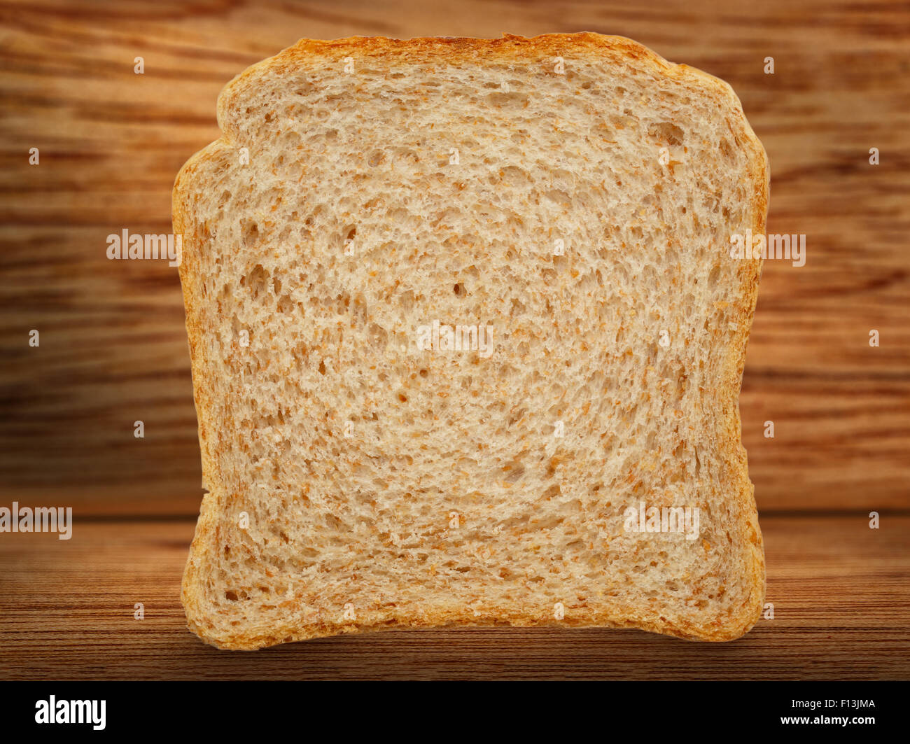 Una fetta di pane su sfondo di legno Foto Stock