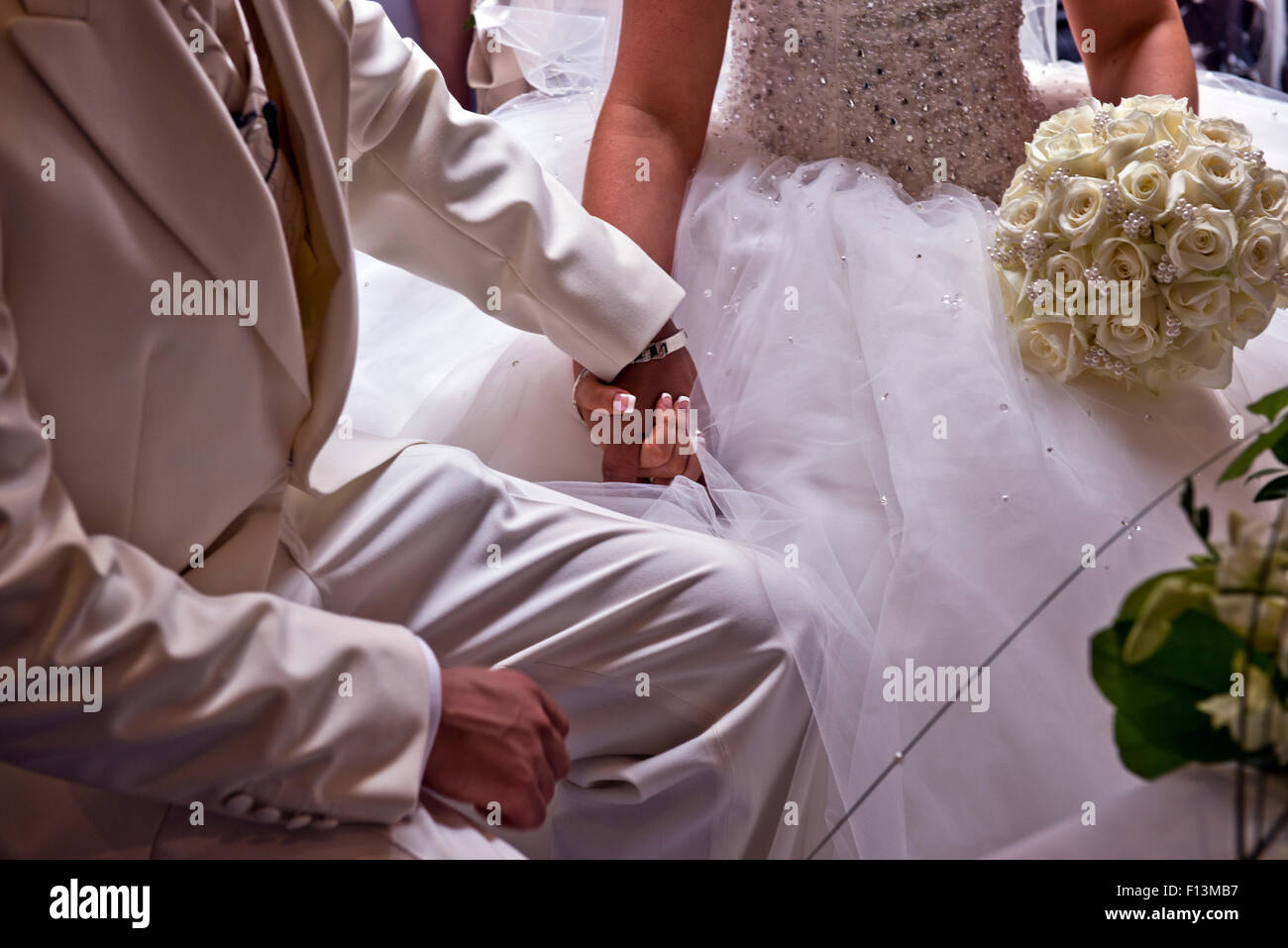 La sposa e lo sposo tenendo le mani attraverso il servizio di nozze. Foto Stock
