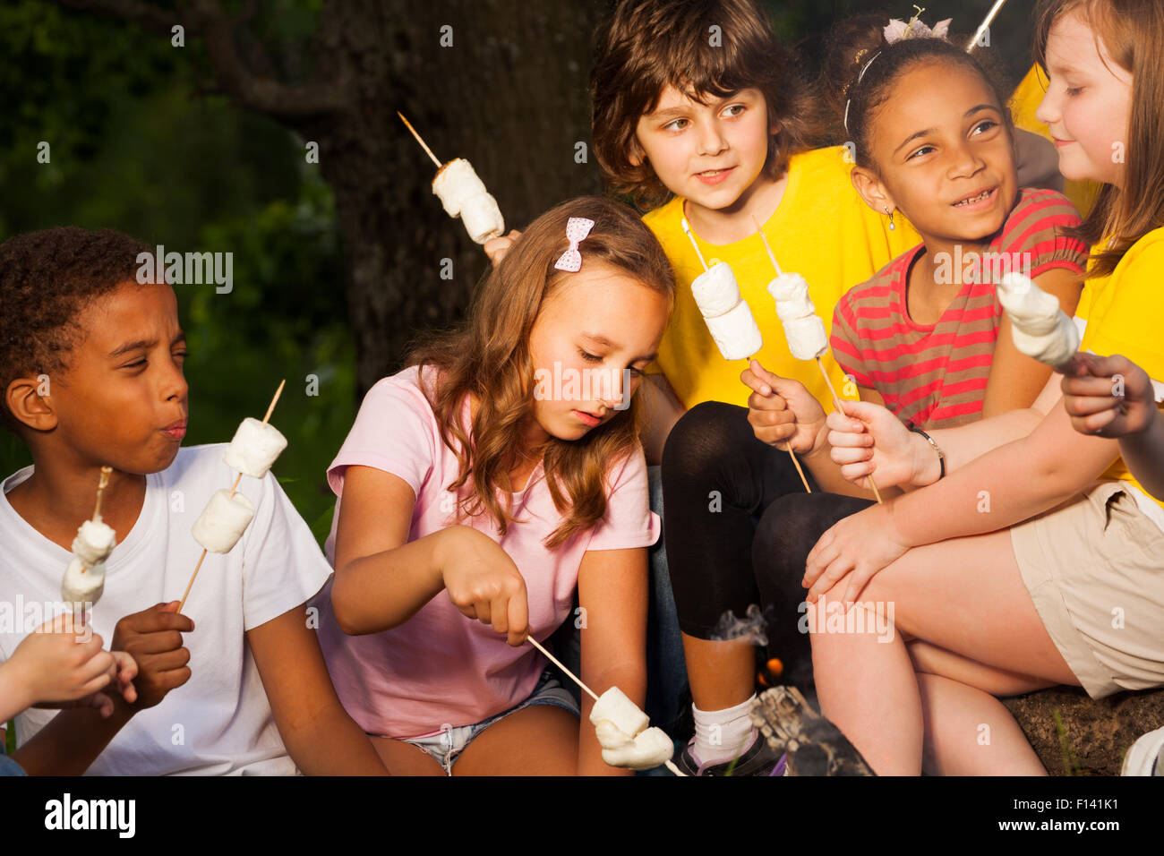 I bambini con il fuoco trattare durante il campeggio Foto Stock