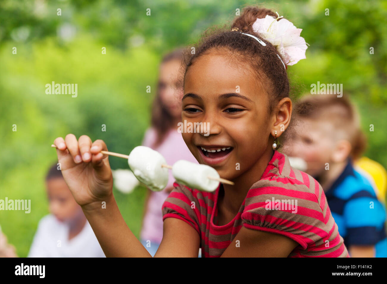 Felice ragazza africana stecco di presa con marshmallow Foto Stock