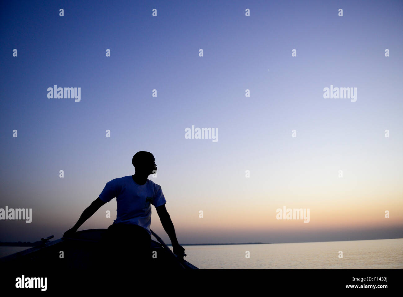 Uomo in aprire il canotto al crepuscolo, Orango Isola, Guinea Bissau, dicembre 2013. Foto Stock