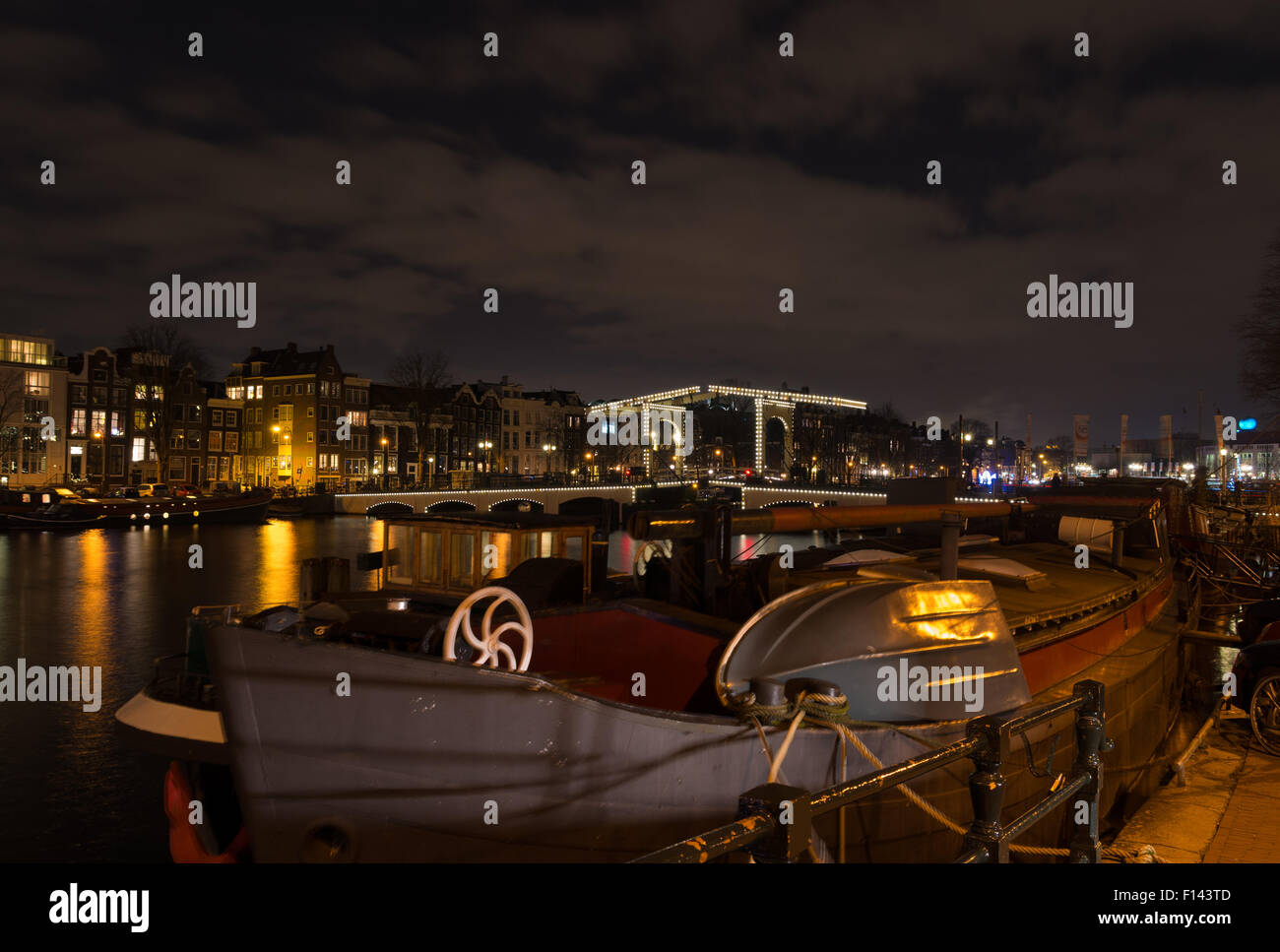 Illuminata sul canale di Amsterdam e ponte levatoio di notte Foto Stock