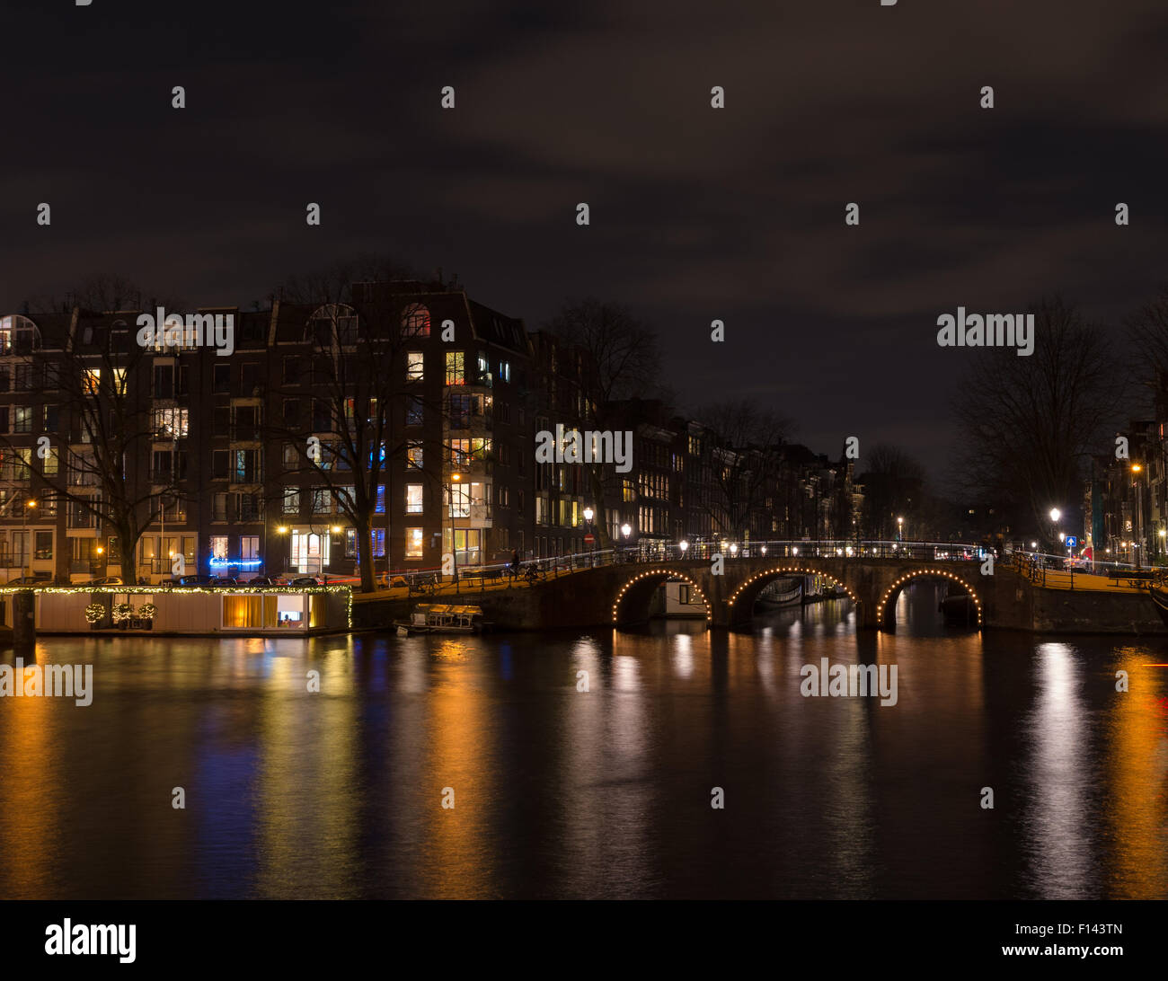 Illuminata amsterdam canal e il ponte di notte Foto Stock