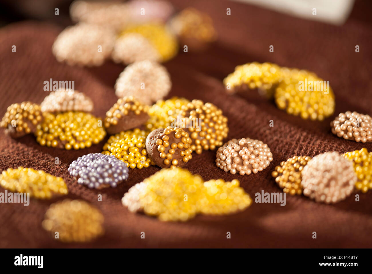 Colorati confetti di cioccolato collocato su un colore marrone scuro igienico Foto Stock